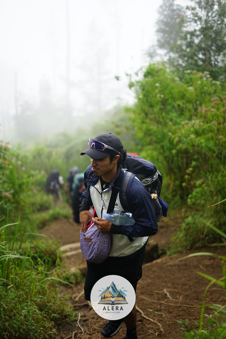 Rombongan pendaki melewati medan berbatu yang menantang, menunjukkan pentingnya koordinasi antara leader dan sweeper.